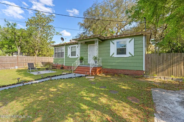 a view of a house with a yard chairs and floor to ceiling window