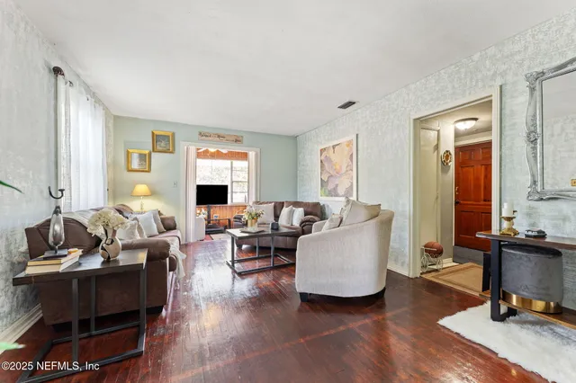 a living room with furniture a wooden floor and a large window