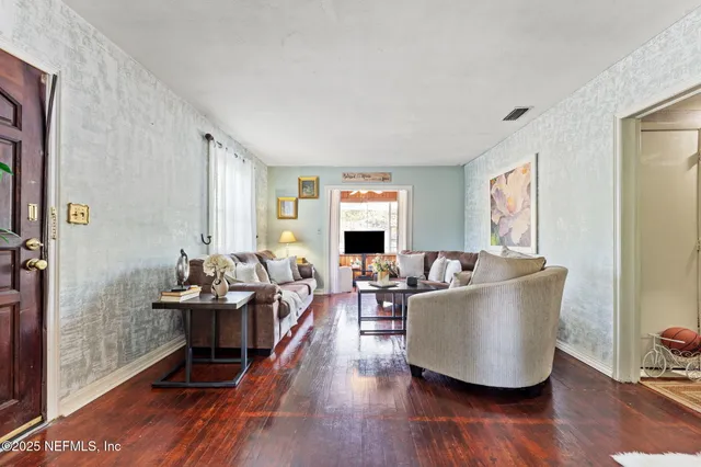 a living room with furniture and wooden floor