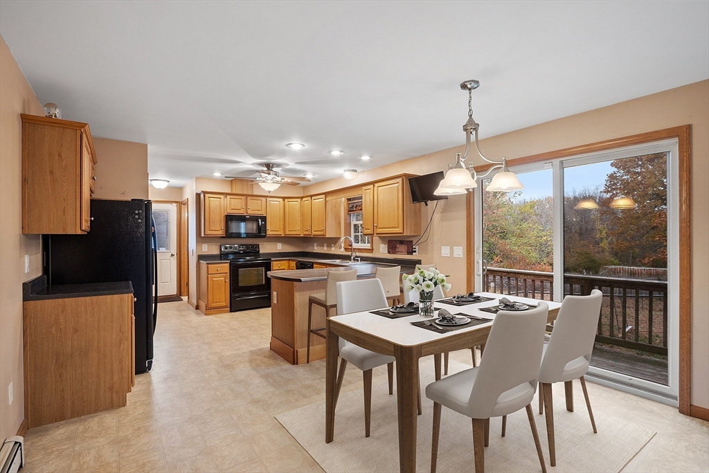819 West Street Lunenburg, MA 01462 - Photo 23 of 42 a kitchen with a table chairs refrigerator and microwave