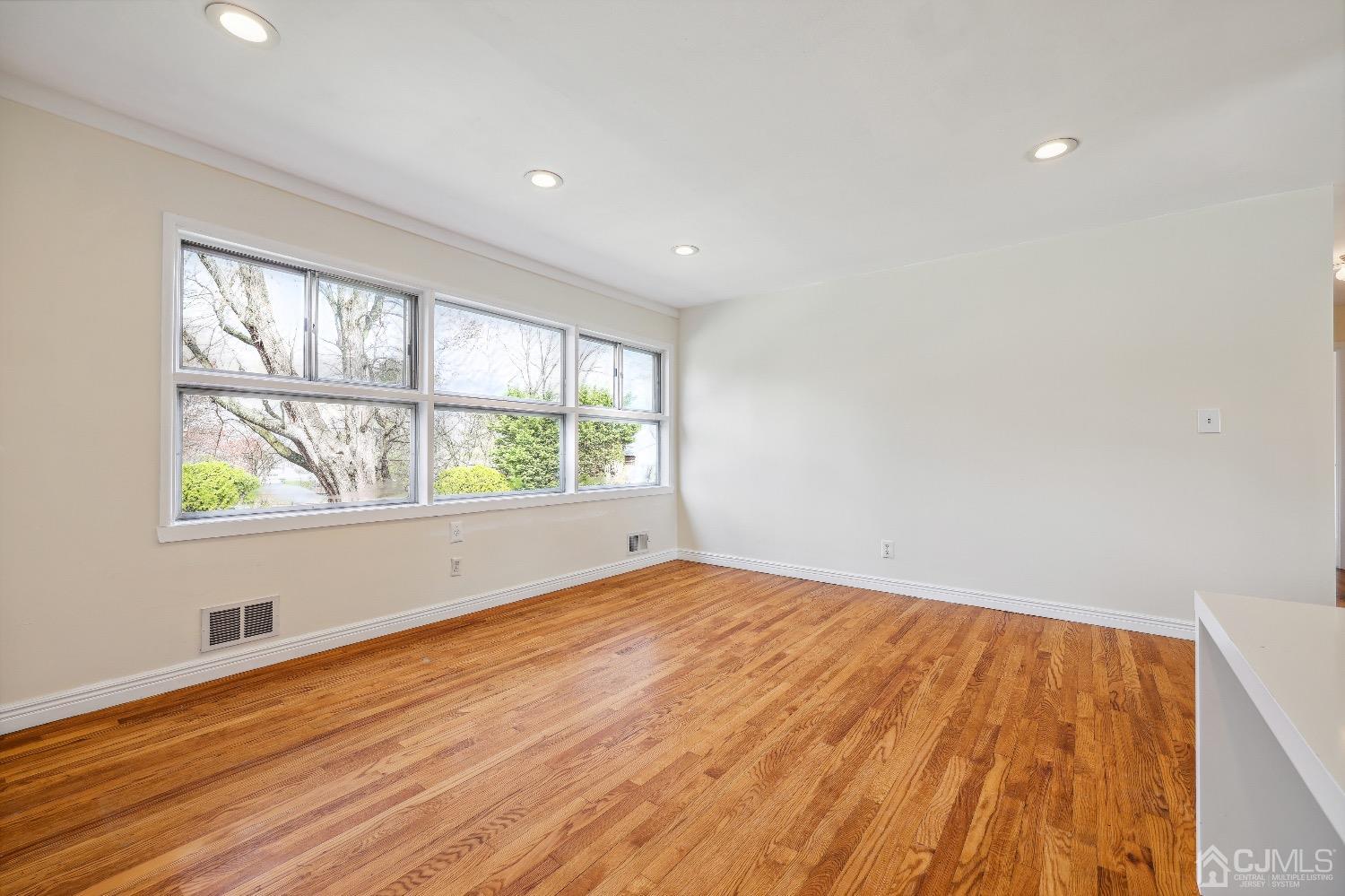 21 Rutgers Road Old Bridge, NJ 08859 - Photo 7 of 27 wooden floor in an empty room with a window