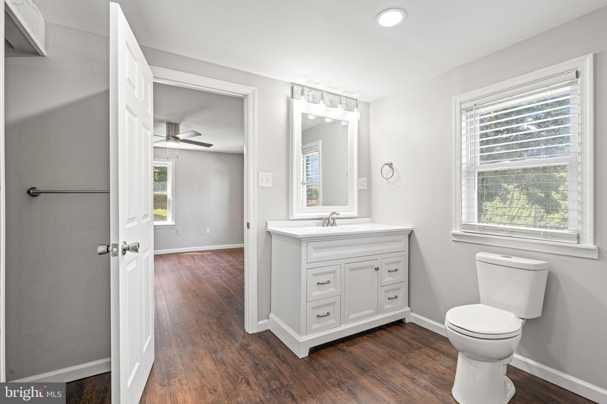 1005 2nd Avenue Manchester, PA 17345 - Photo 29 of 54 a bathroom with a granite countertop toilet a sink a mirror and a window