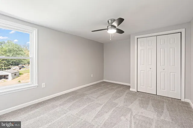 an empty room with windows and closet