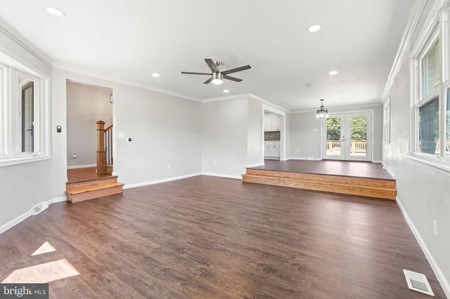 a view of an empty room with window and wooden floor
