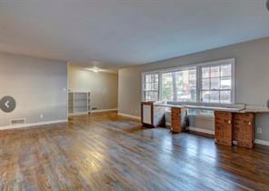 909 Duncan Lane, Unit A Austin, TX 78705 - Photo 10 of 18 a view of an empty room with a window and wooden floor