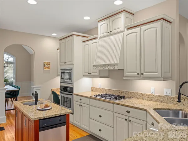 a kitchen with granite countertop a sink stove and cabinets