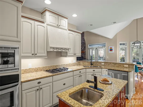 a kitchen with granite countertop a sink a stove and cabinets