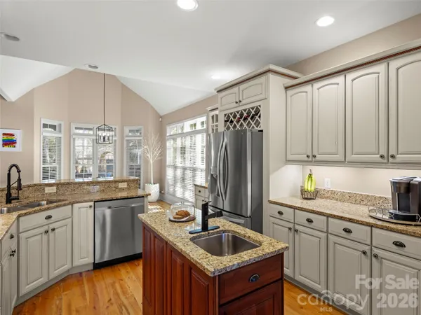 a kitchen with granite countertop a sink stove and cabinets
