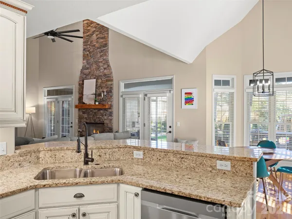 a kitchen with a granite countertop sink and natural light