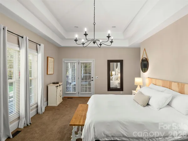 a bedroom with a large bed and a chandelier