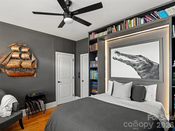 a bedroom with a bed and a painting on the wall