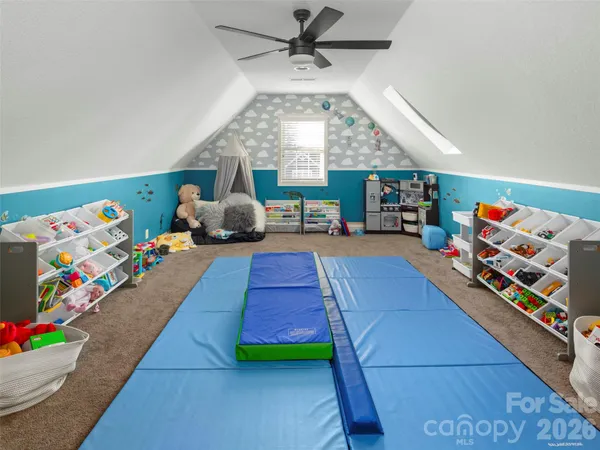 a living room with furniture and a baby crib