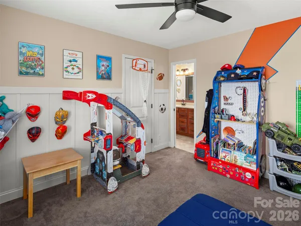 a view of play room with toys and a ceiling fan