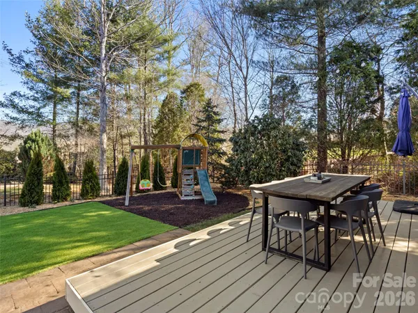 a view of a patio with table and chairs with wooden floor and fence