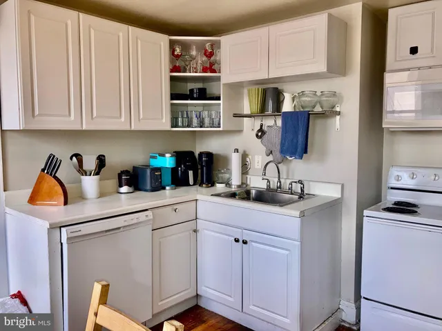 a kitchen with stainless steel appliances granite countertop a sink a stove and white cabinets