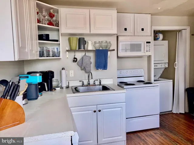 a kitchen with stainless steel appliances cabinets and a wooden floor