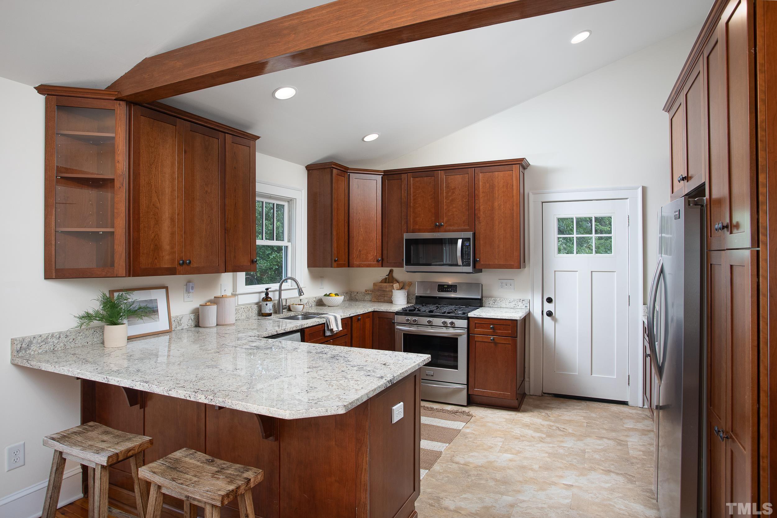 1218 North Roxboro Street Durham, NC 27701 - Photo 11 of 39 a kitchen with stainless steel appliances granite countertop a sink a stove a refrigerator cabinets and chairs