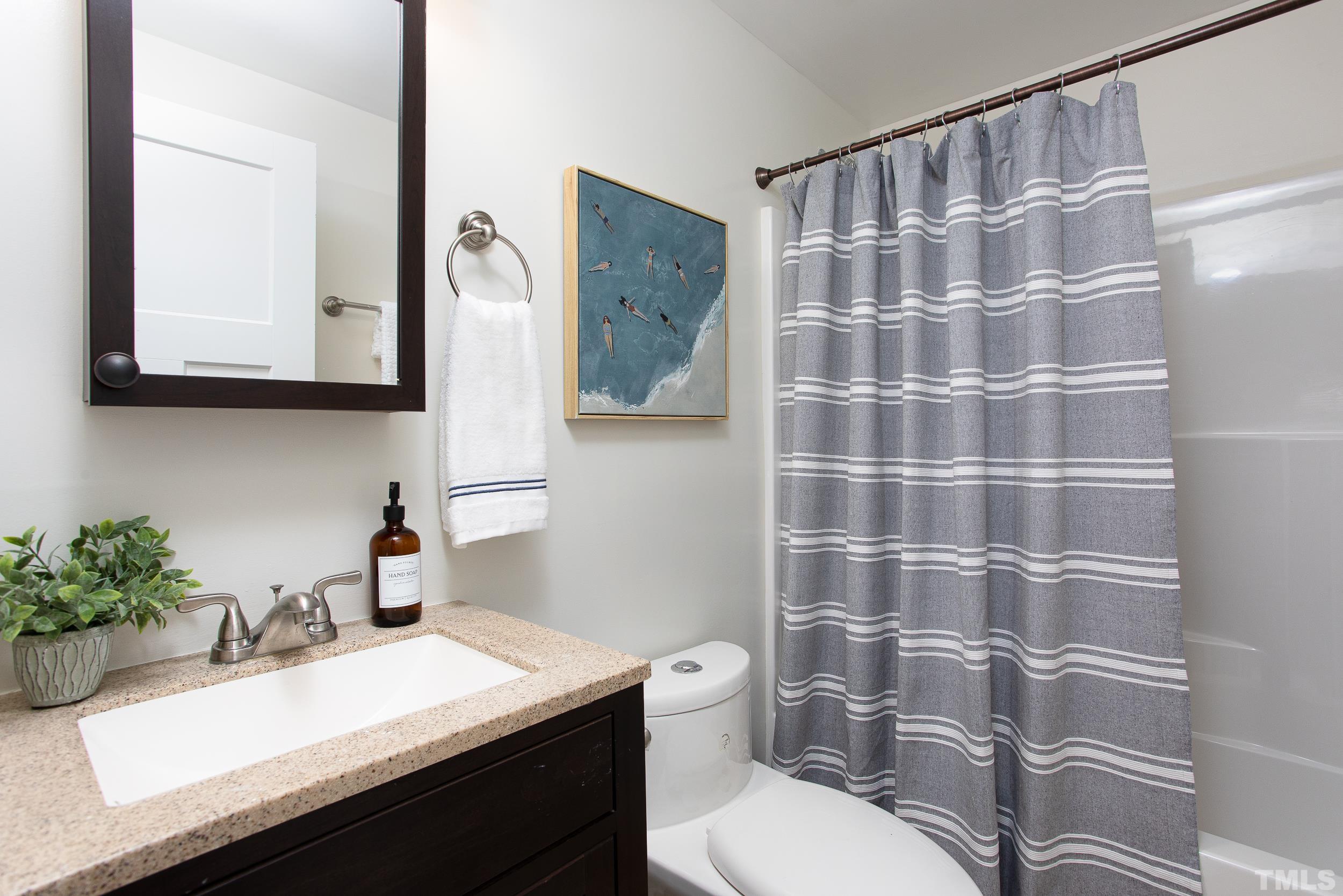 1218 North Roxboro Street Durham, NC 27701 - Photo 34 of 39 a bathroom with a sink a toilet and shower curtain