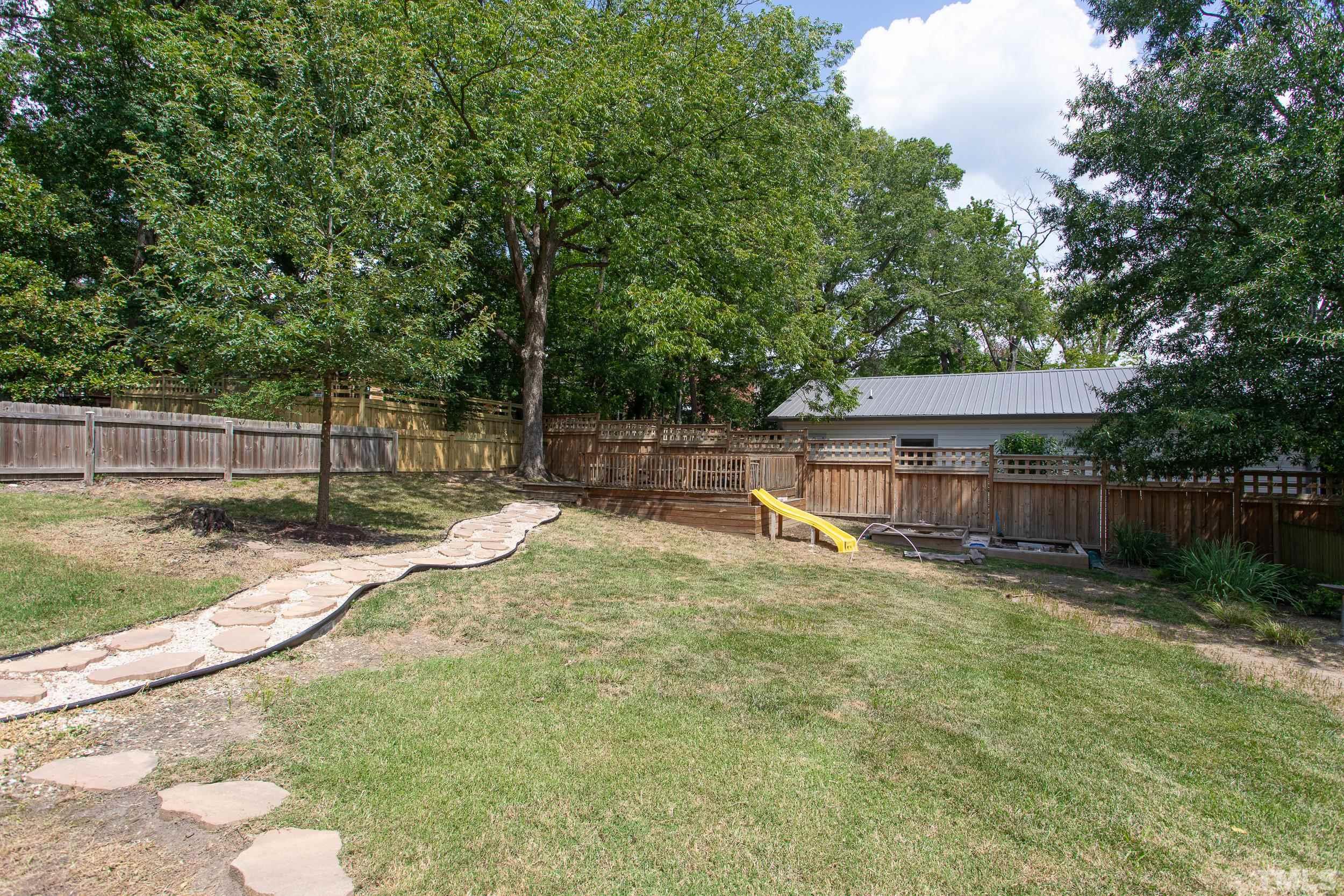 1218 North Roxboro Street Durham, NC 27701 - Photo 38 of 39 a backyard of a house with large trees and wooden fence