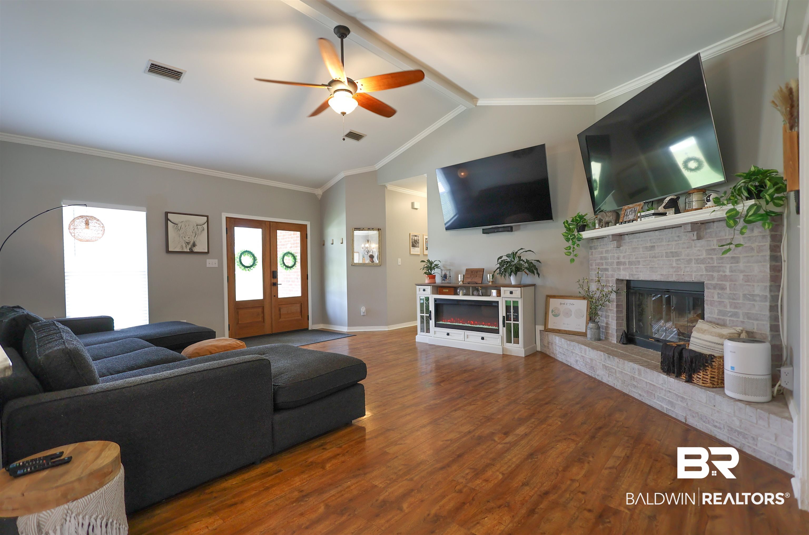 5151 Beatrice Road Gulf Shores, AL 36542 - Photo 9 of 50 Living area featuring beamed ceiling, a ceiling fan, wood finished floors, crown molding, and a fireplace