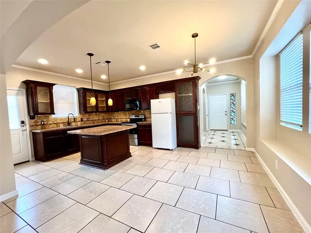 a large kitchen with a large counter top stainless steel appliances and cabinets