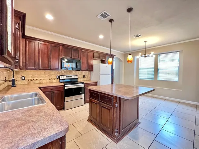 a kitchen with stainless steel appliances granite countertop wooden cabinets a sink and a stove