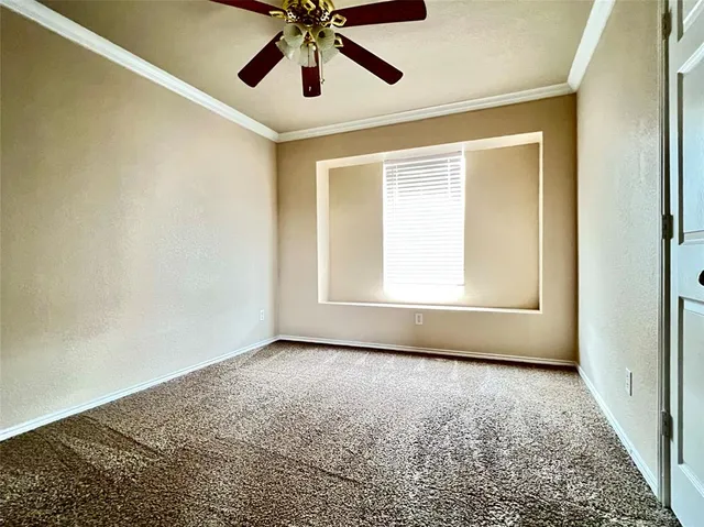 an empty room with fan and windows