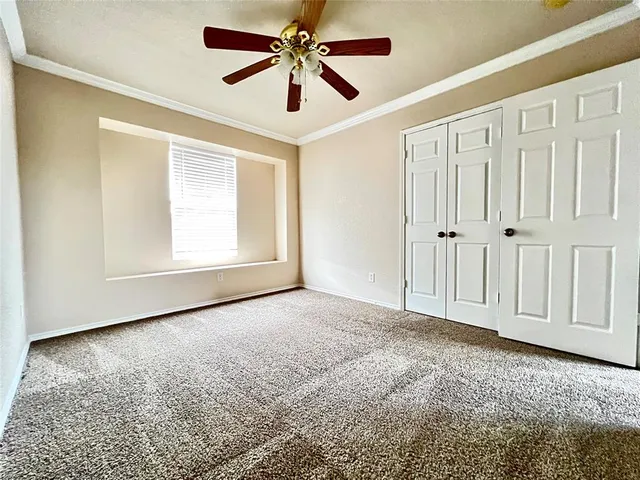 an empty room with chandelier fan