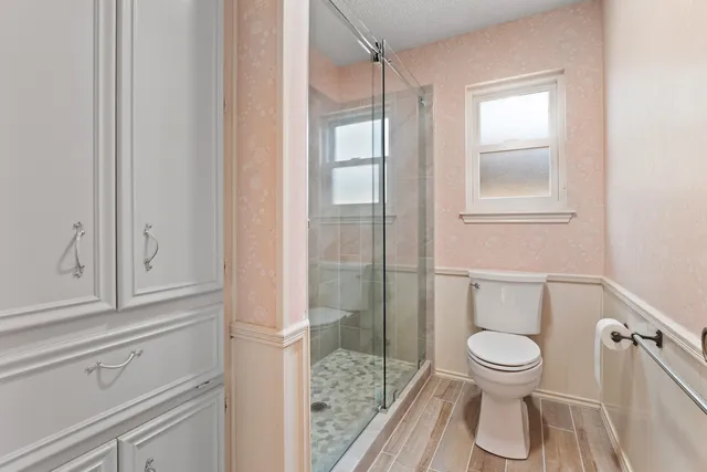 a bathroom with a toilet and a shower