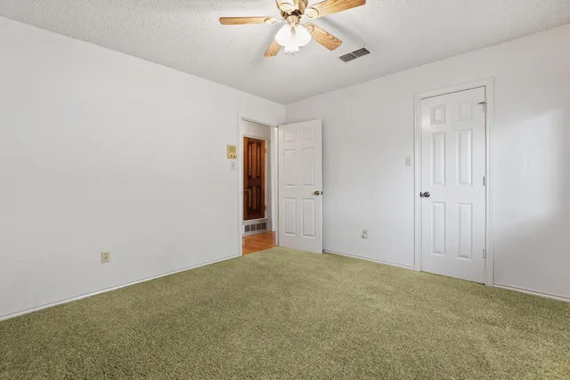 a view of an empty room with a ceiling fan