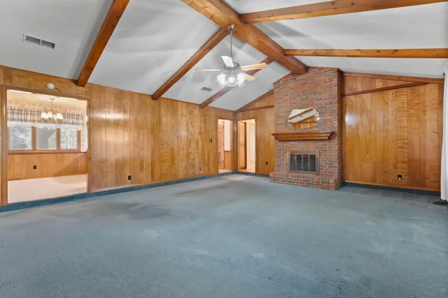 a view of an empty room with a fireplace and a window