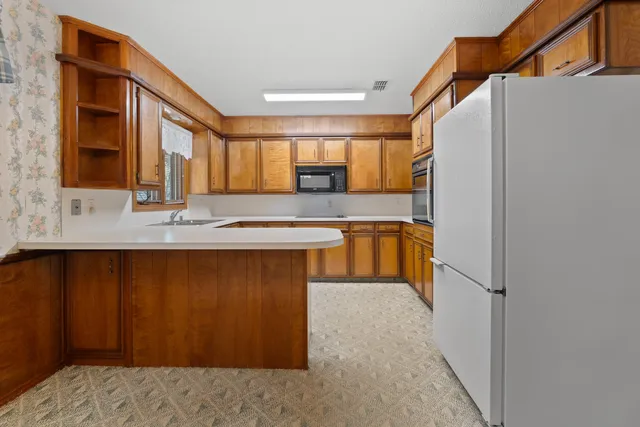a kitchen with stainless steel appliances granite countertop a stove a sink and a refrigerator