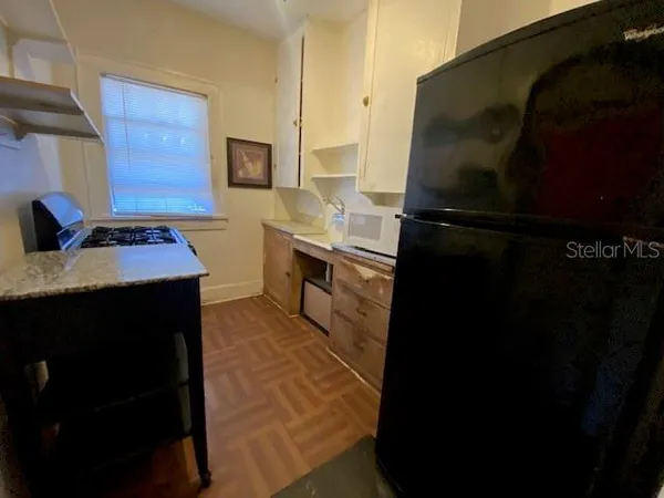 a kitchen with a sink refrigerator and cabinets
