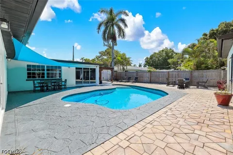 a view of a swimming pool with a patio and plants
