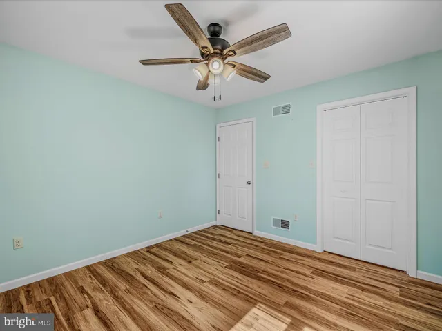 wooden floor in an empty room with a fan