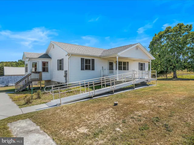 a view of a house with pool and chairs