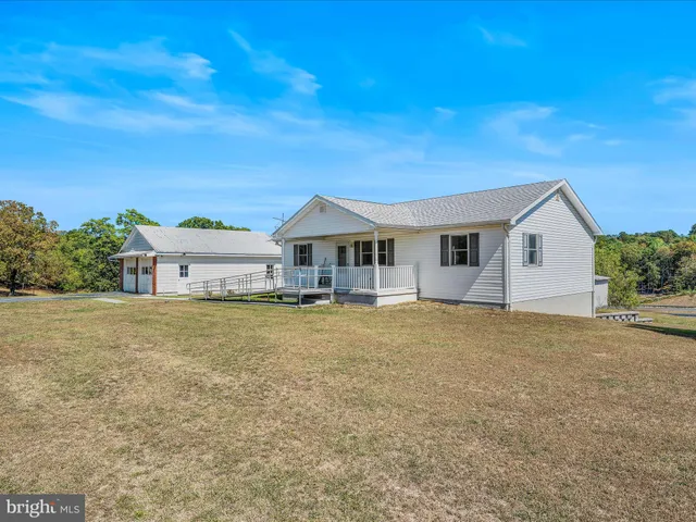 a front view of house with yard and trees in the background