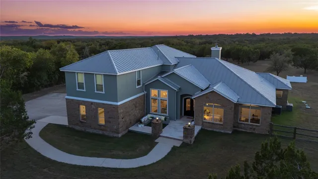 a aerial view of a house with a yard table and chairs