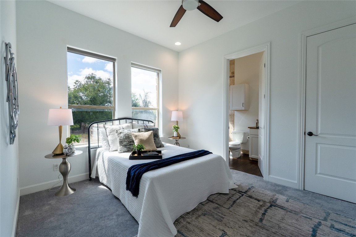 724 Chama Trace Dripping Springs, TX 78620 - Photo 21 of 40 a bedroom with a bed and large windows