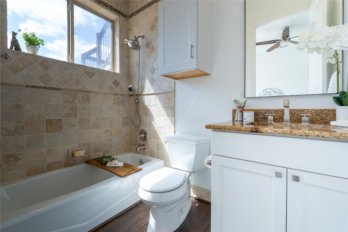 724 Chama Trace Dripping Springs, TX 78620 - Photo 22 of 40 a bathroom with a granite countertop sink a toilet and bathtub