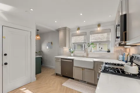 a kitchen with stainless steel appliances a sink stove and refrigerator