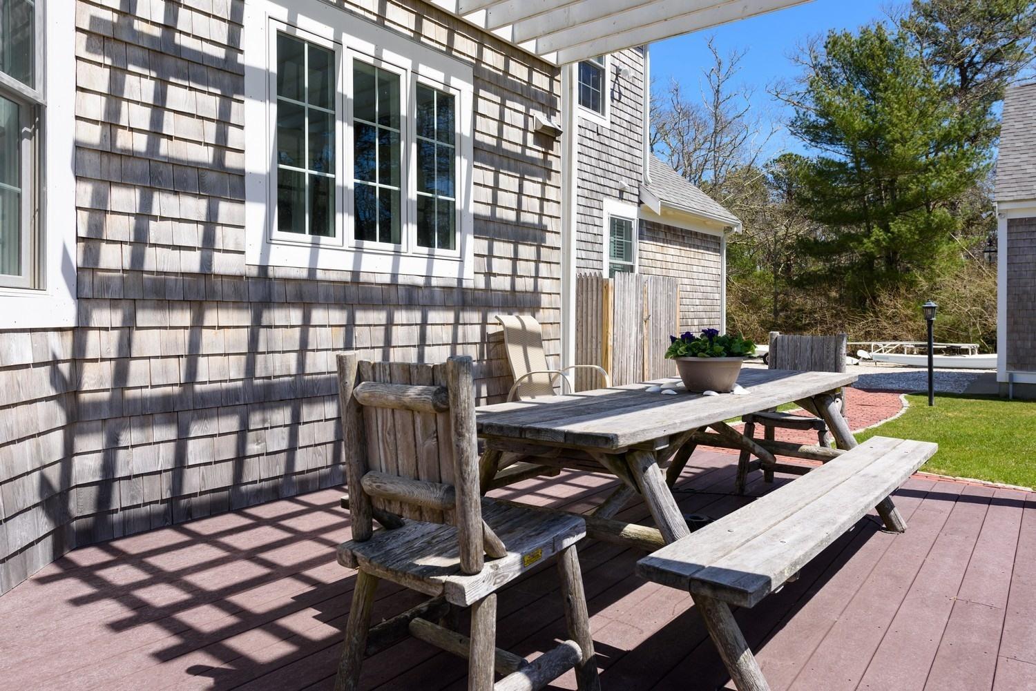 425 Scraggy Neck Road Cataumet, MA 02534 - Photo 11 of 32 a roof deck with table and chairs and potted plants