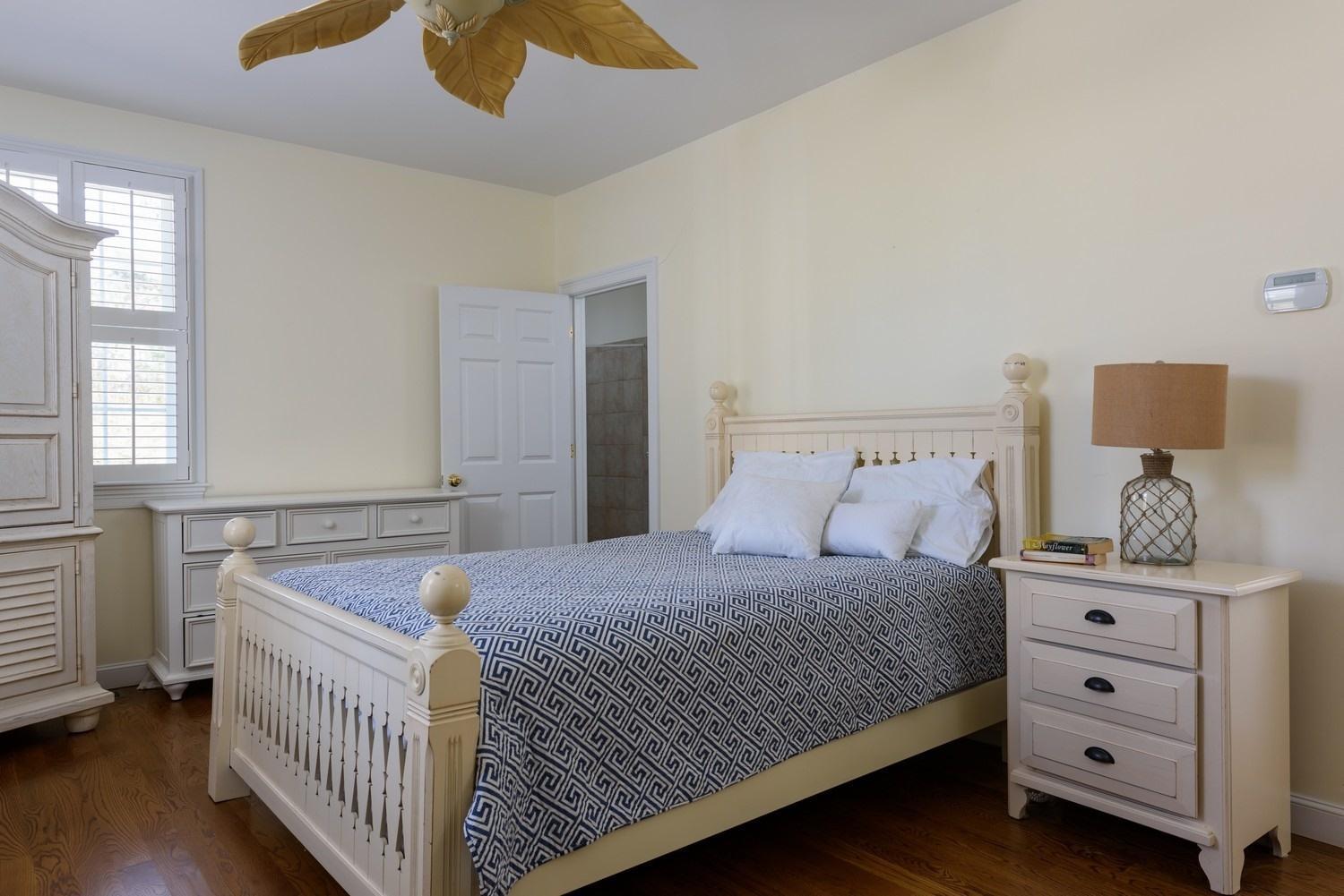 425 Scraggy Neck Road Cataumet, MA 02534 - Photo 14 of 32 a bedroom with a bed and wooden floor