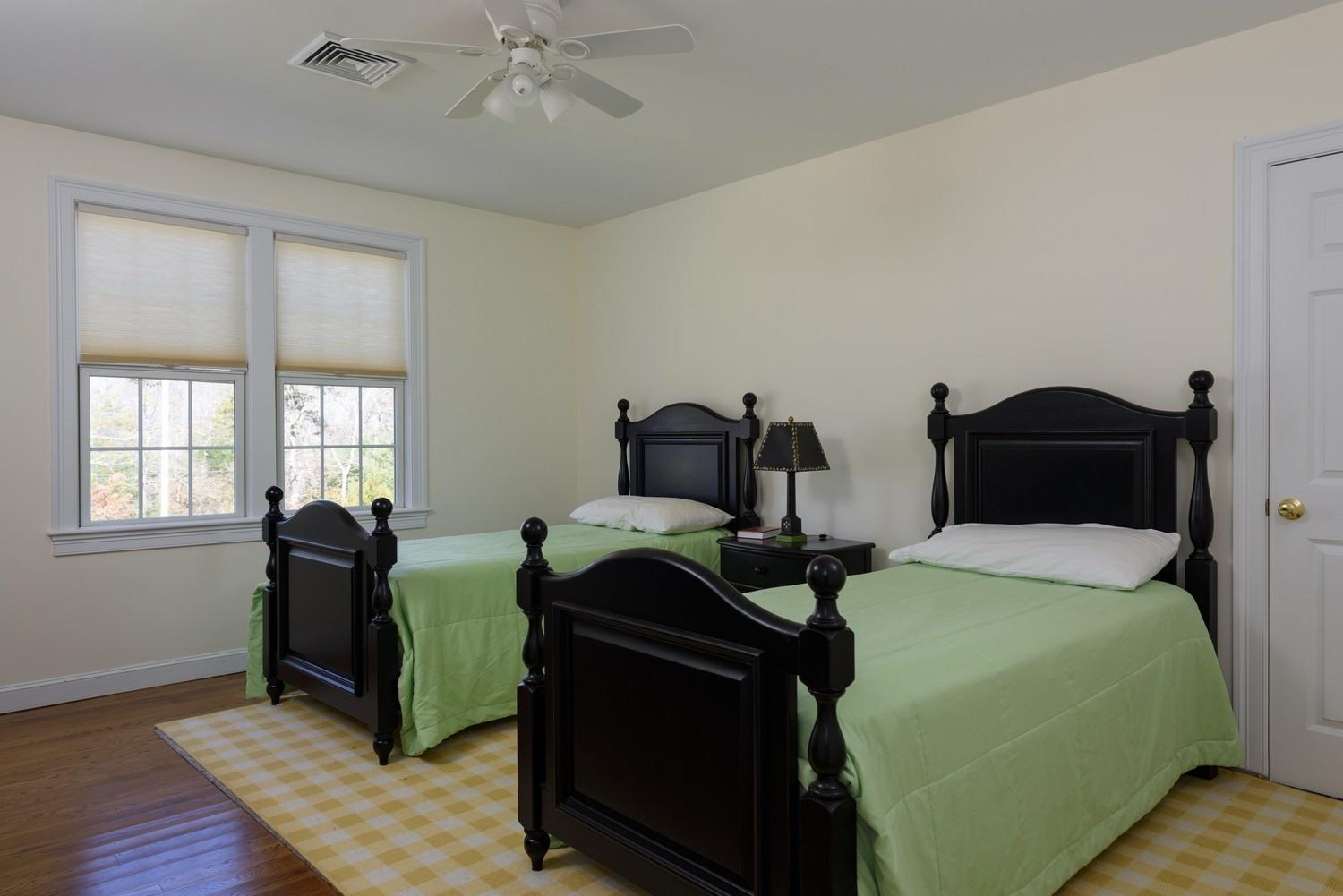 425 Scraggy Neck Road Cataumet, MA 02534 - Photo 18 of 32 a bedroom with two beds and wooden floor