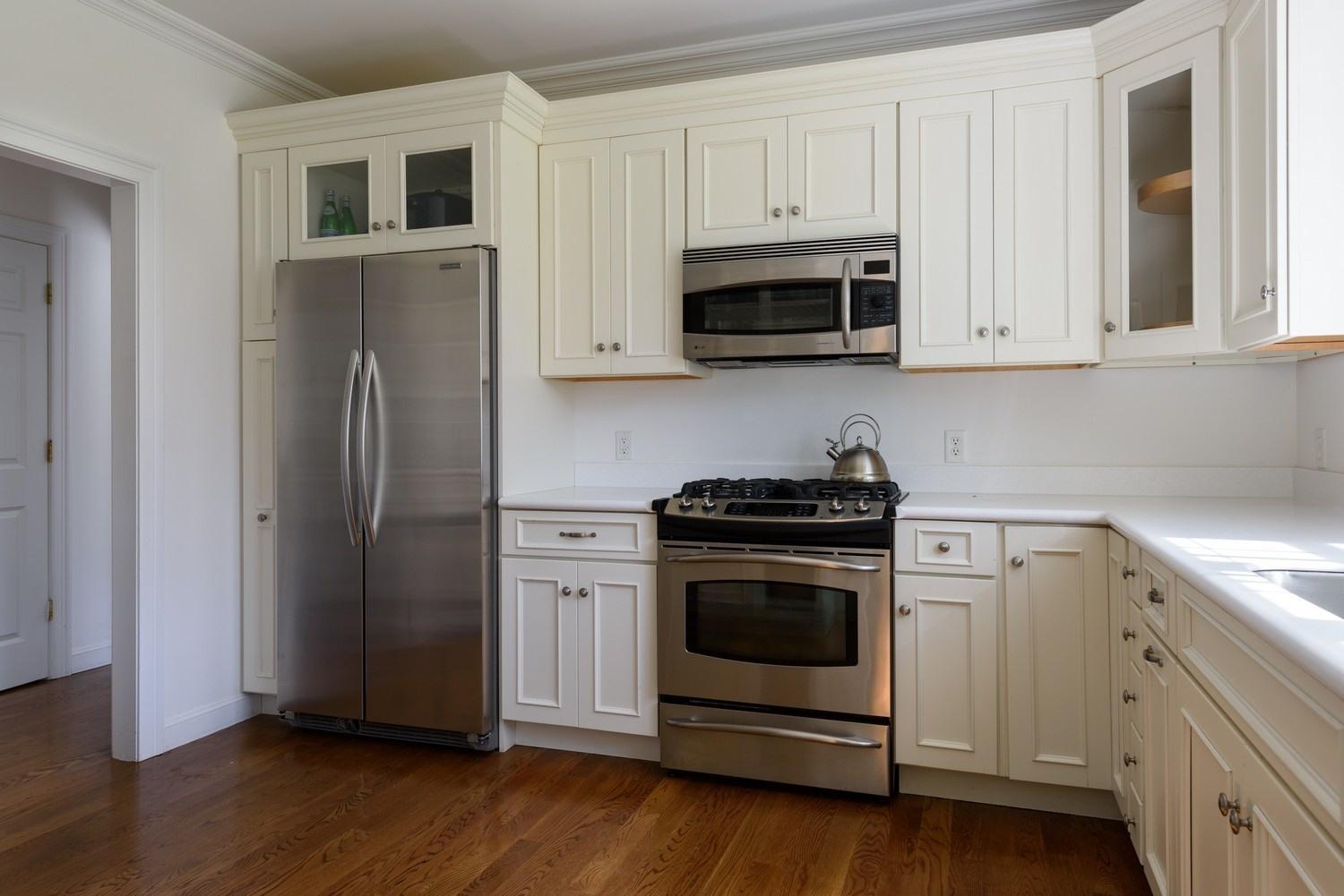 425 Scraggy Neck Road Cataumet, MA 02534 - Photo 9 of 32 a kitchen with stainless steel appliances white cabinets a stove a microwave and a refrigerator