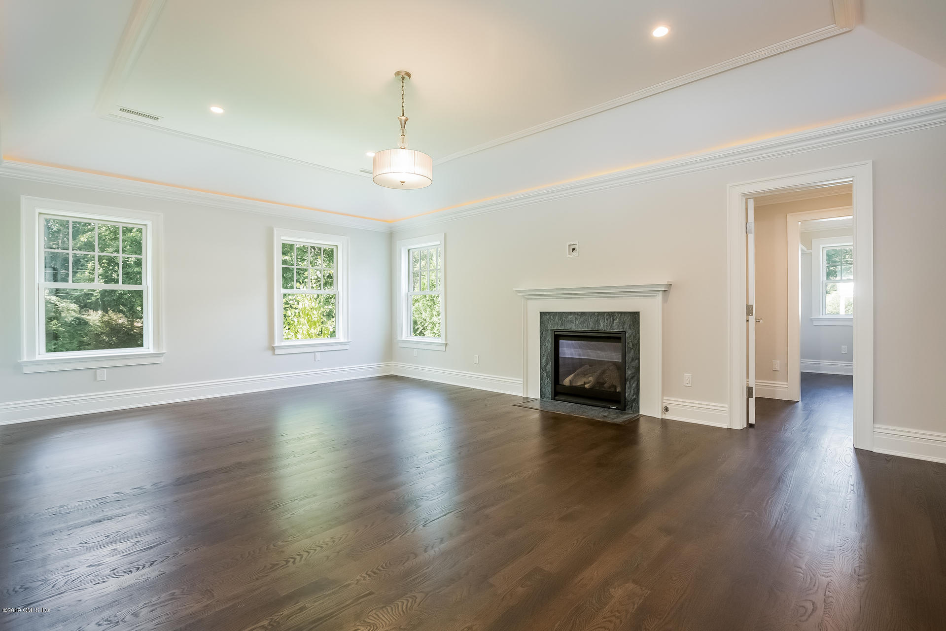 15 Cottontail Road Cos Cob, CT 06807 - Photo 9 of 13 an empty room with wooden floor fireplace and windows