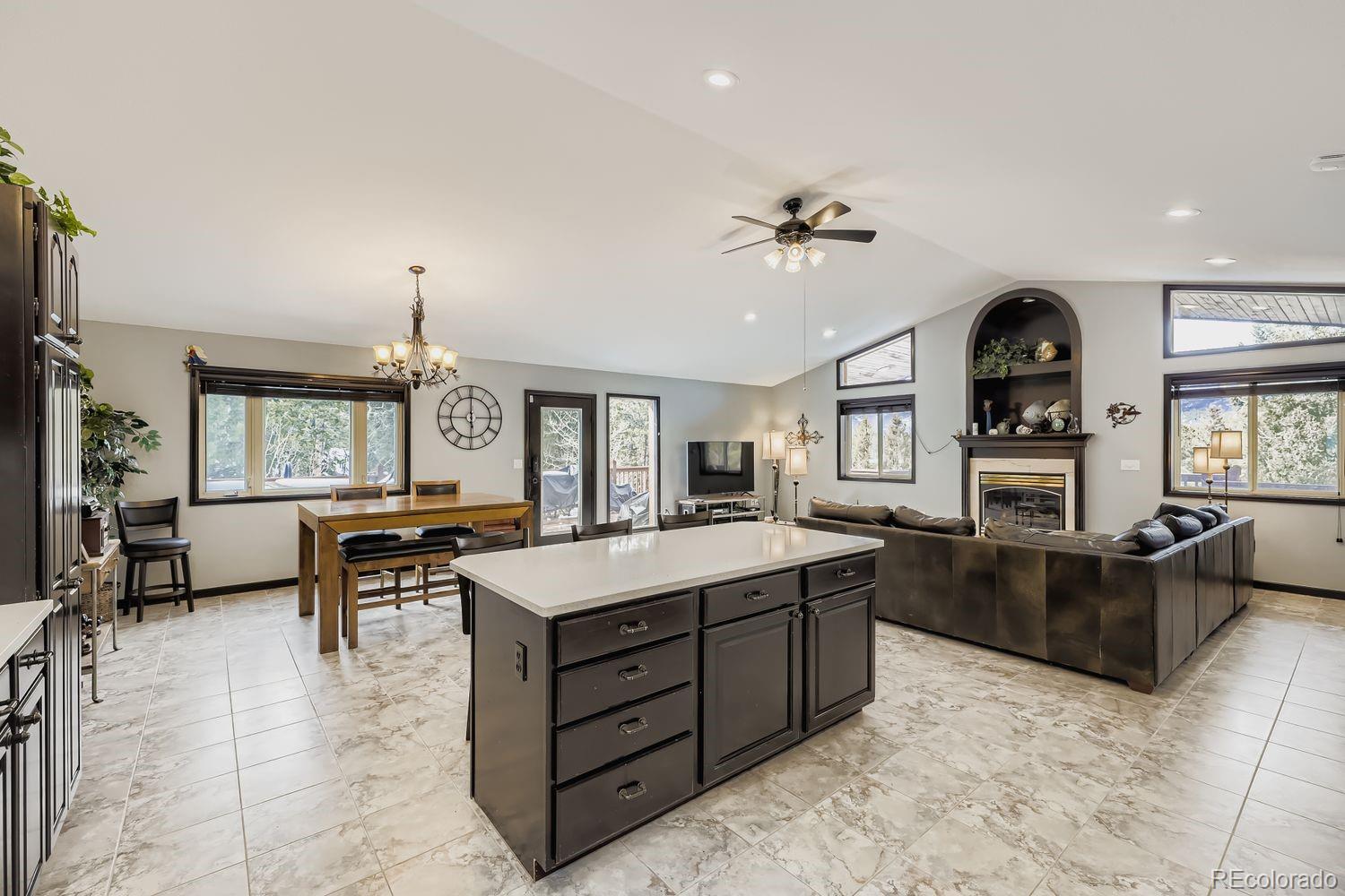 296 Desperado Road Bailey, CO 80421 - Photo 12 of 37 a large living room with granite countertop furniture a fireplace and a large window