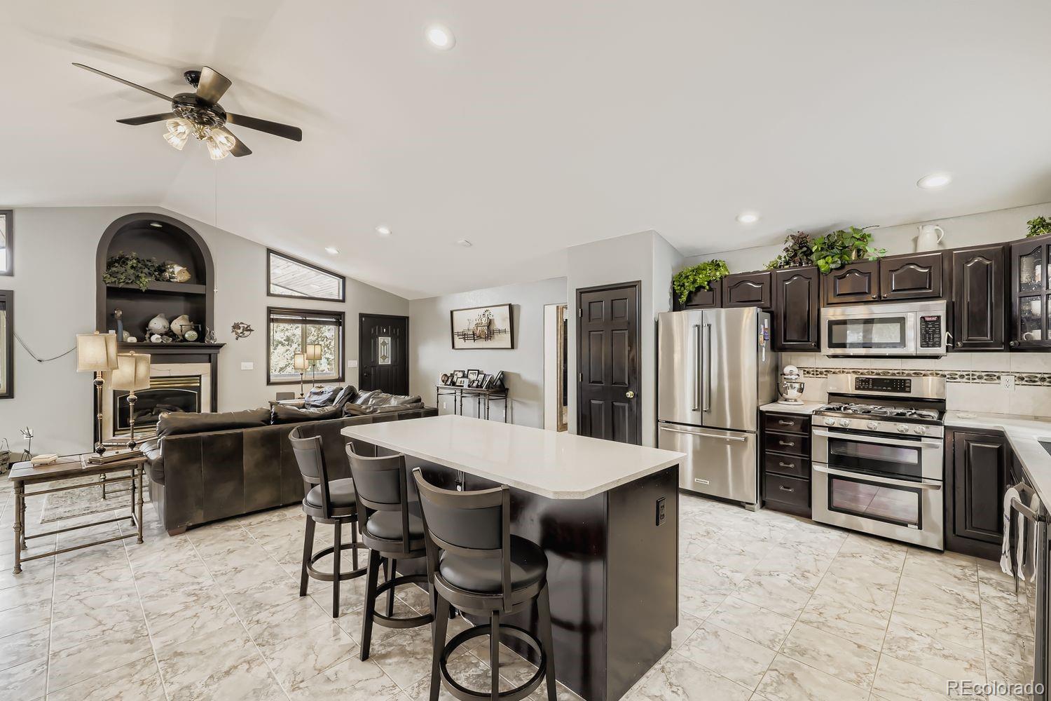 296 Desperado Road Bailey, CO 80421 - Photo 16 of 38 a kitchen with stainless steel appliances a stove a refrigerator a sink a dining table and chairs