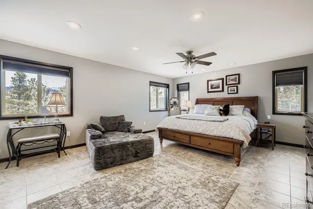 a bedroom with furniture and a large window