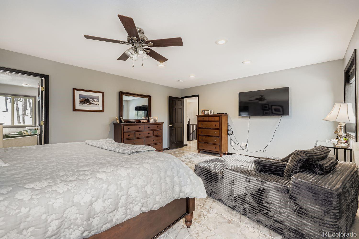 296 Desperado Road Bailey, CO 80421 - Photo 20 of 37 a bedroom with a bed and a flat screen tv